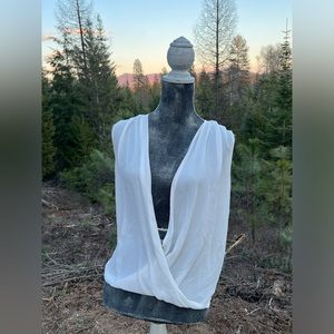 Sheer, white sleeveless blouse with plunging neck line.